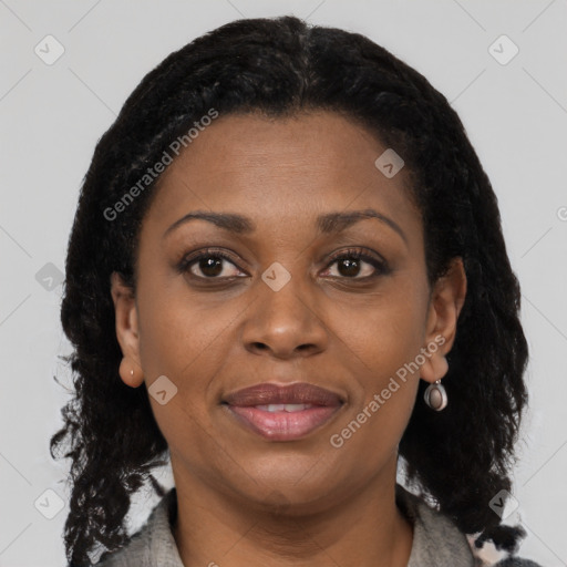 Joyful black young-adult female with long  black hair and brown eyes
