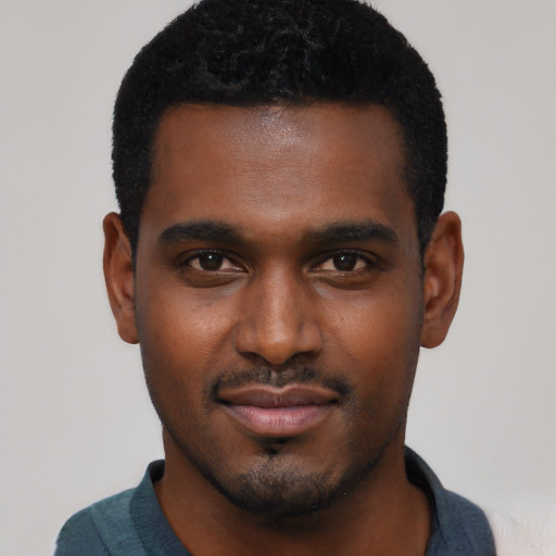 Joyful black young-adult male with short  black hair and brown eyes