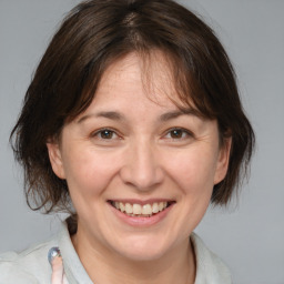 Joyful white adult female with medium  brown hair and brown eyes