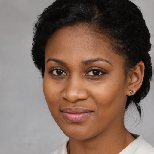 Joyful black young-adult female with medium  brown hair and brown eyes