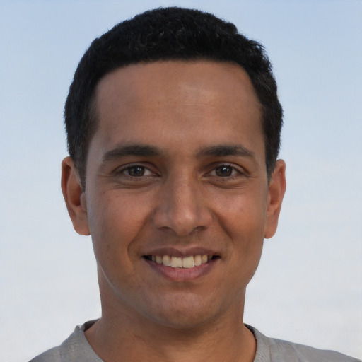 Joyful latino young-adult male with short  black hair and brown eyes