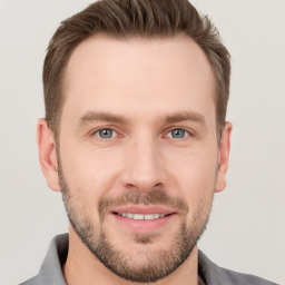 Joyful white young-adult male with short  brown hair and grey eyes