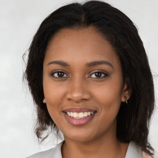 Joyful black young-adult female with long  brown hair and brown eyes