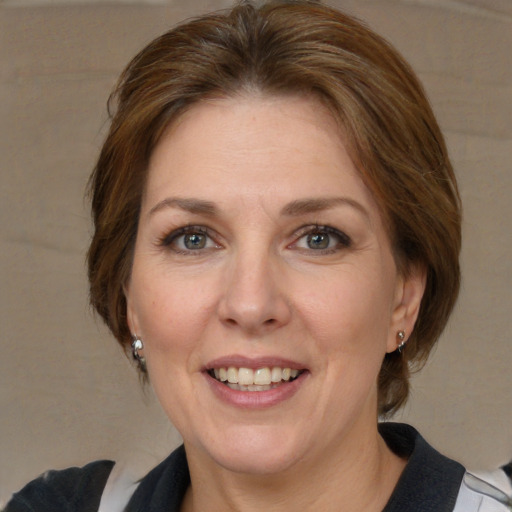 Joyful white adult female with medium  brown hair and blue eyes