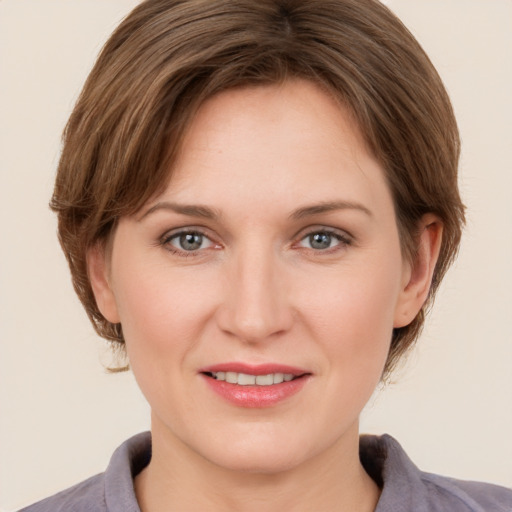 Joyful white young-adult female with medium  brown hair and grey eyes