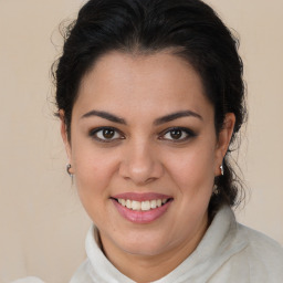 Joyful latino young-adult female with medium  brown hair and brown eyes