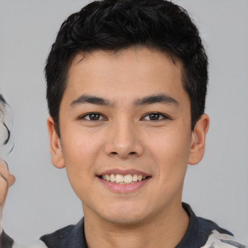 Joyful asian young-adult male with short  black hair and brown eyes