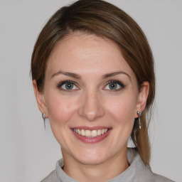 Joyful white young-adult female with medium  brown hair and blue eyes