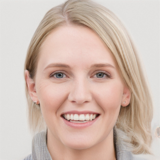 Joyful white young-adult female with medium  brown hair and blue eyes