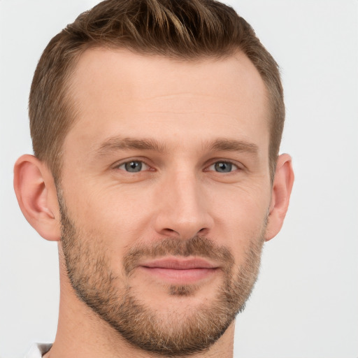 Joyful white young-adult male with short  brown hair and grey eyes