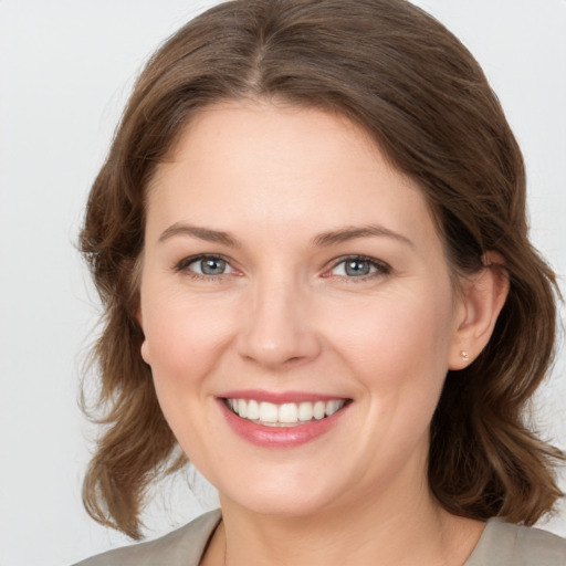 Joyful white young-adult female with medium  brown hair and grey eyes