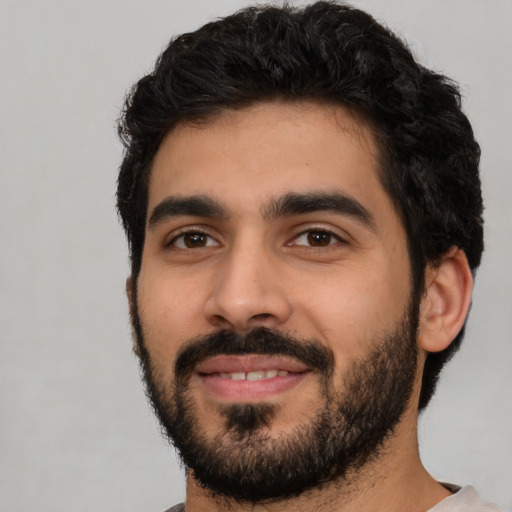 Joyful latino young-adult male with short  black hair and brown eyes