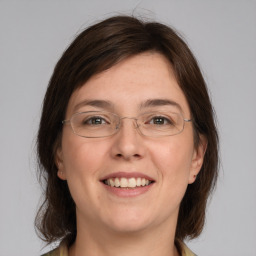 Joyful white young-adult female with medium  brown hair and grey eyes