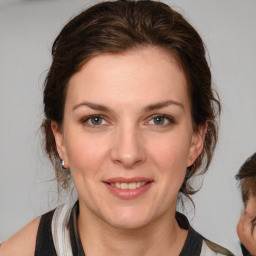 Joyful white young-adult female with medium  brown hair and grey eyes