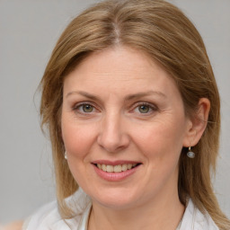 Joyful white adult female with medium  brown hair and blue eyes