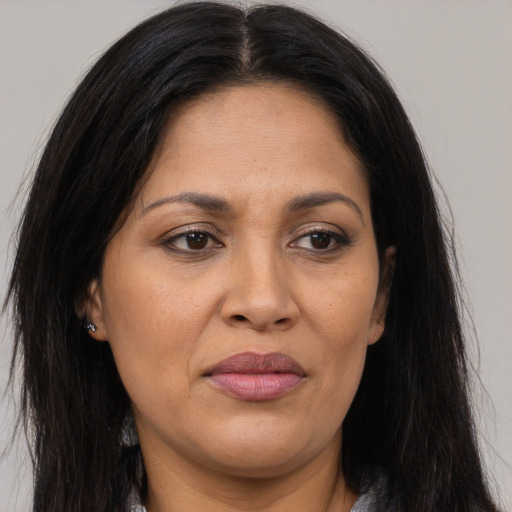 Joyful latino adult female with long  brown hair and brown eyes