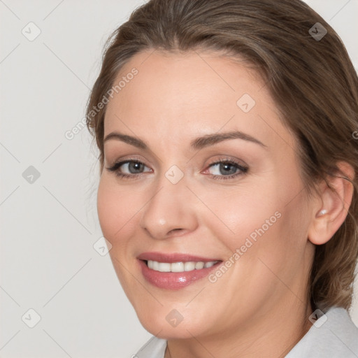 Joyful white young-adult female with medium  brown hair and grey eyes