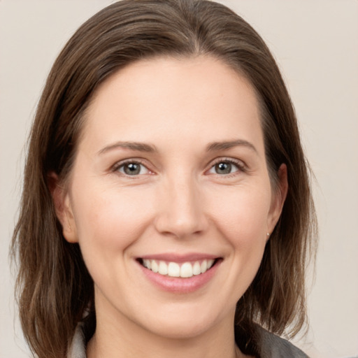 Joyful white young-adult female with medium  brown hair and grey eyes