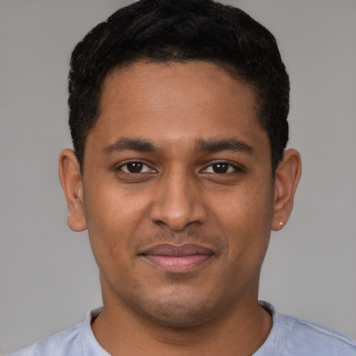 Joyful black young-adult male with short  brown hair and brown eyes