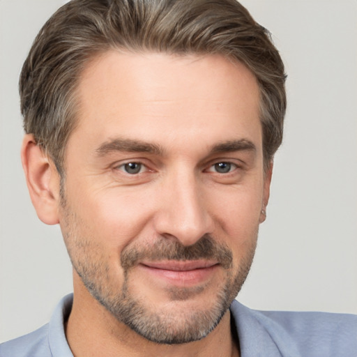 Joyful white adult male with short  brown hair and brown eyes