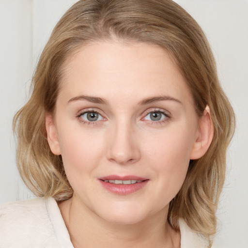 Joyful white young-adult female with medium  brown hair and blue eyes