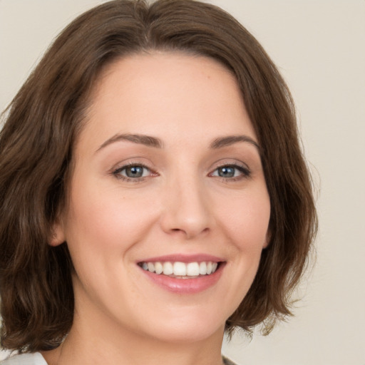 Joyful white young-adult female with medium  brown hair and green eyes