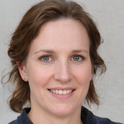 Joyful white adult female with medium  brown hair and blue eyes