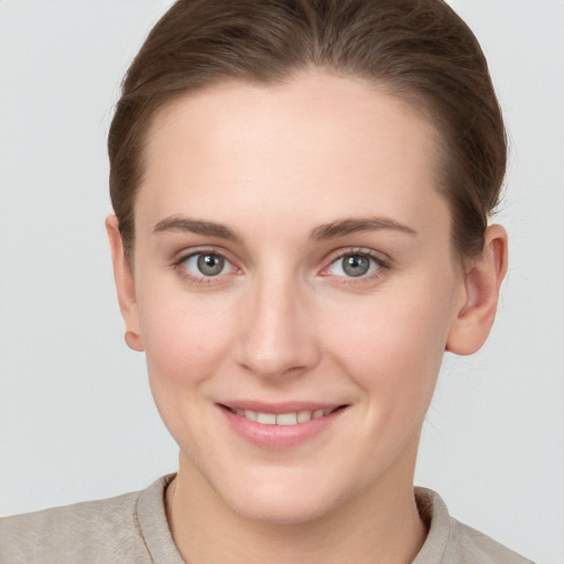 Joyful white young-adult female with short  brown hair and grey eyes