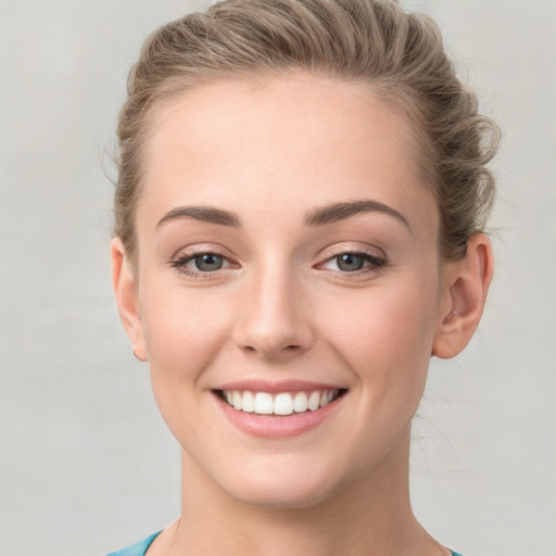 Joyful white young-adult female with short  brown hair and blue eyes