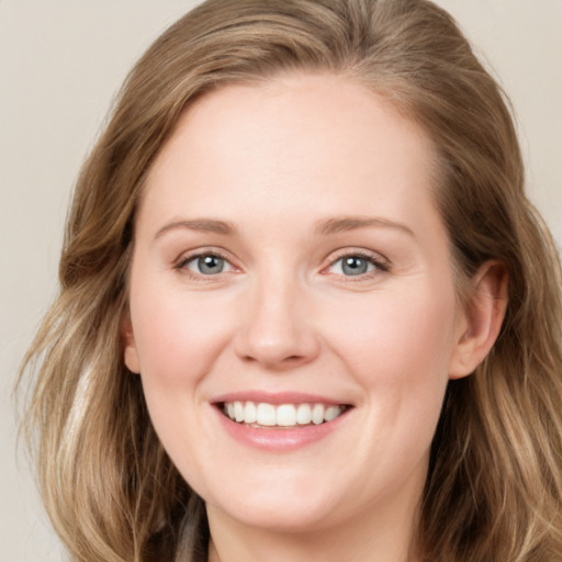 Joyful white young-adult female with long  brown hair and blue eyes