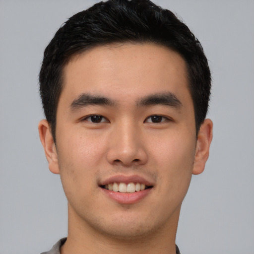 Joyful asian young-adult male with short  brown hair and brown eyes