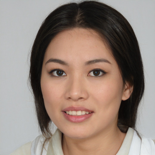 Joyful latino young-adult female with medium  brown hair and brown eyes