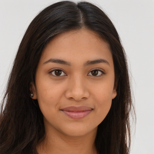 Joyful latino young-adult female with long  brown hair and brown eyes