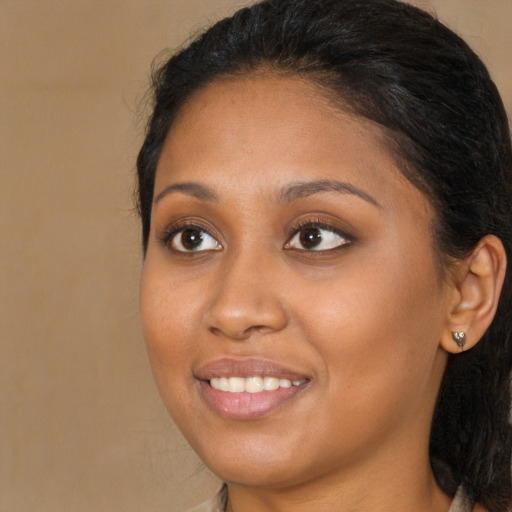 Joyful black young-adult female with long  brown hair and brown eyes