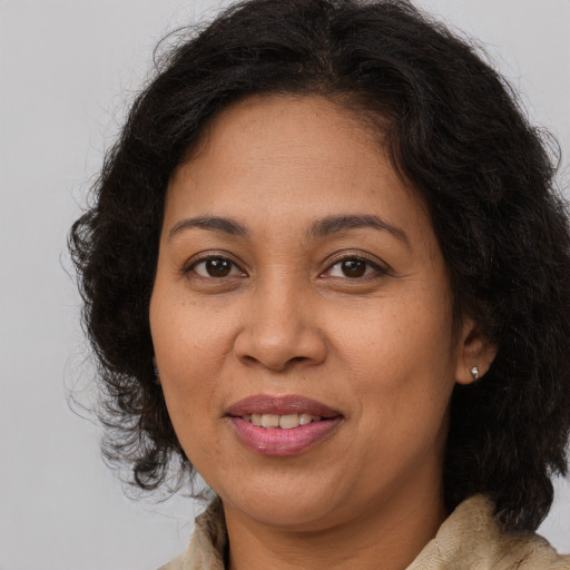 Joyful latino adult female with long  brown hair and brown eyes