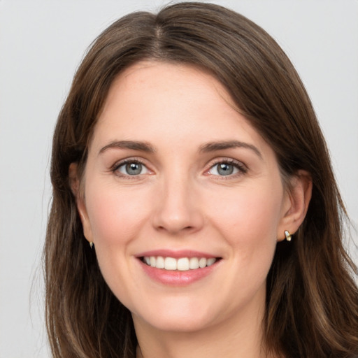 Joyful white young-adult female with long  brown hair and grey eyes