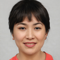 Joyful asian young-adult female with short  brown hair and brown eyes