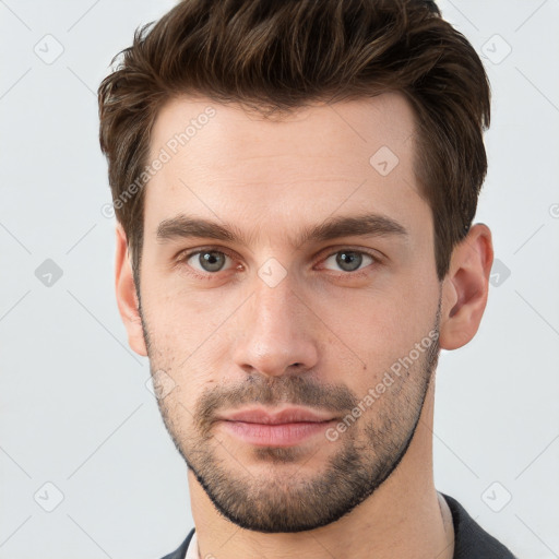 Joyful white young-adult male with short  brown hair and grey eyes