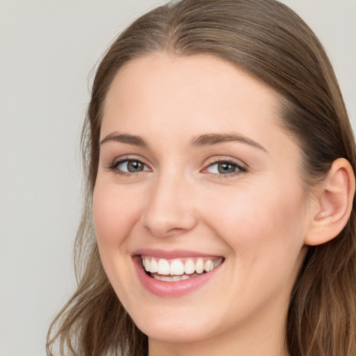 Joyful white young-adult female with long  brown hair and blue eyes