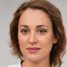 Joyful white young-adult female with medium  brown hair and green eyes