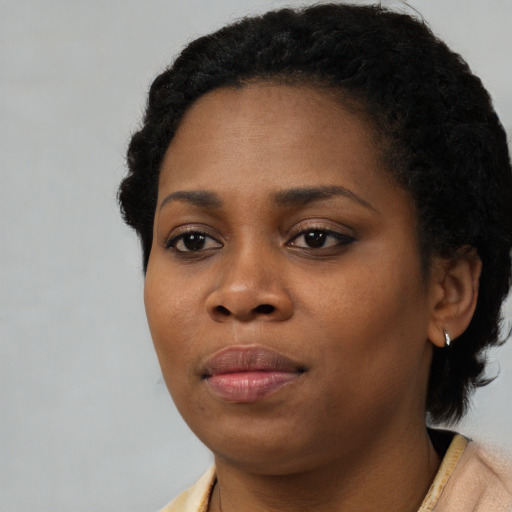 Joyful black young-adult female with short  black hair and brown eyes