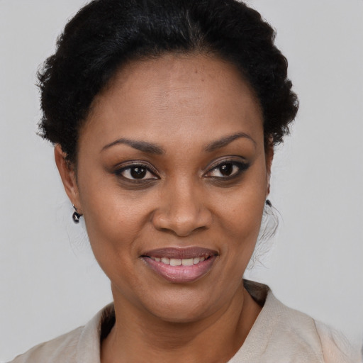 Joyful black young-adult female with short  black hair and brown eyes