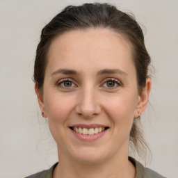 Joyful white young-adult female with medium  brown hair and grey eyes