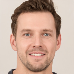 Joyful white young-adult male with short  brown hair and grey eyes