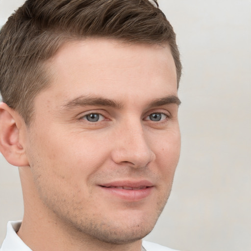 Joyful white young-adult male with short  brown hair and grey eyes