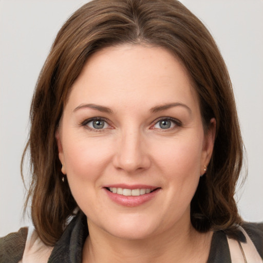 Joyful white young-adult female with medium  brown hair and grey eyes