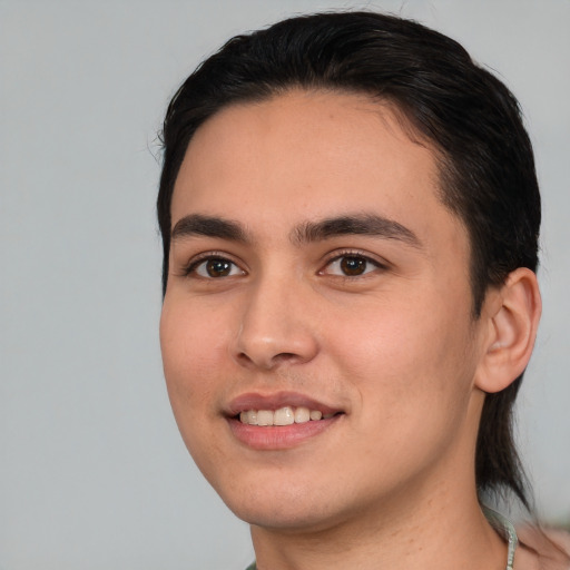 Joyful white young-adult male with medium  black hair and brown eyes