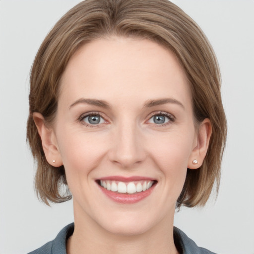 Joyful white young-adult female with medium  brown hair and grey eyes