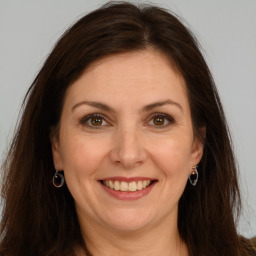 Joyful white adult female with long  brown hair and brown eyes