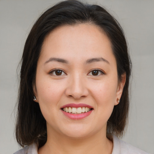 Joyful asian young-adult female with medium  brown hair and brown eyes